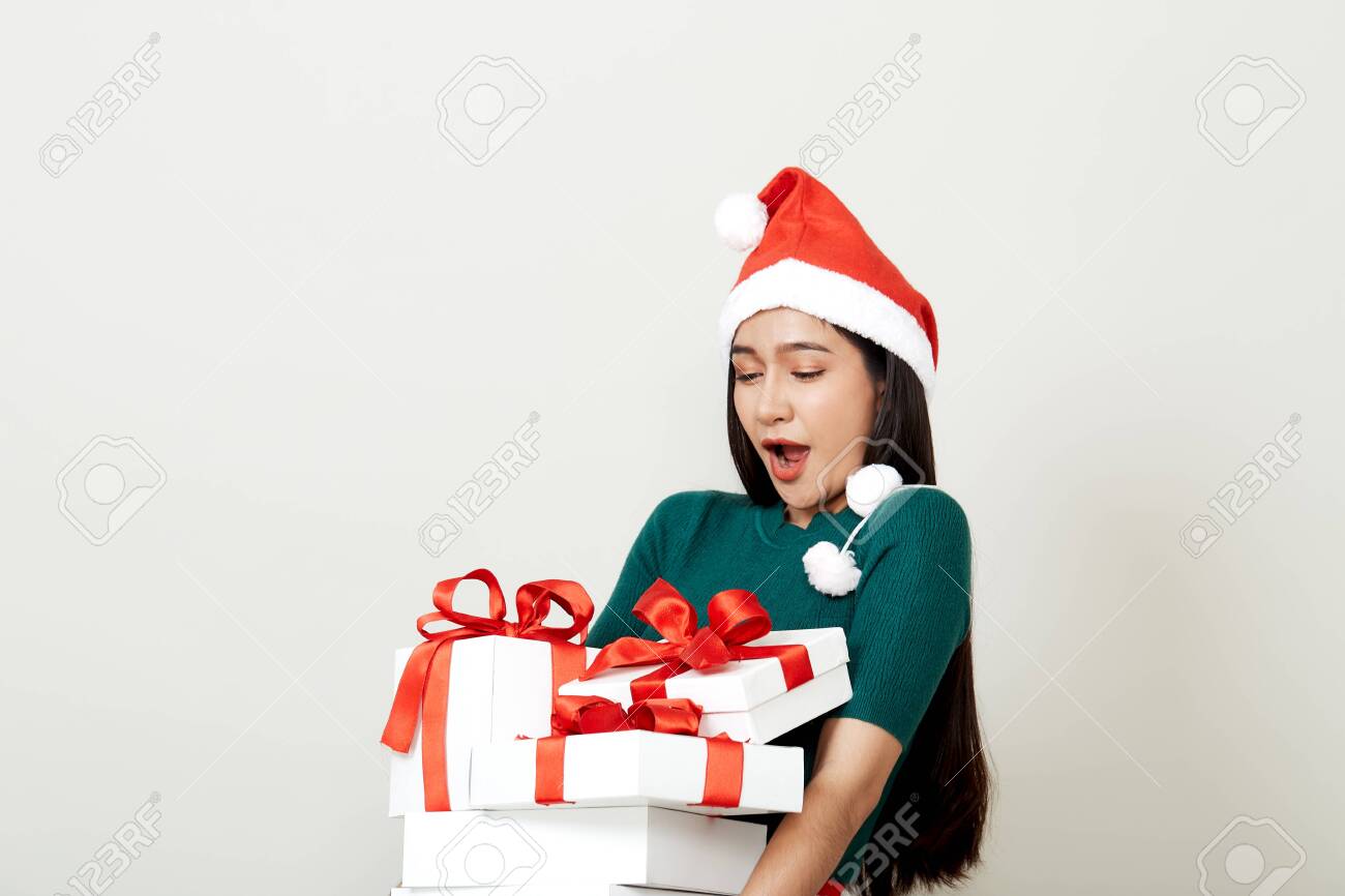 Beautiful Asian woman in in santa hat with many gifts studio shot isolated on bright gray background, copy space for text, Christmas Concept and new year - 134721750 Beautiful Asian woman in in santa hat with many gifts studio shot isolated on bright gray background, copy space for text, Christmas Concept and new year - 134721750