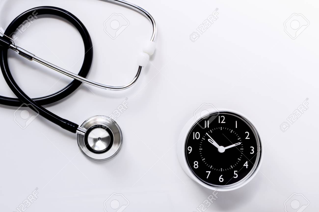 stethoscope with a clock on white table background the stethoscope