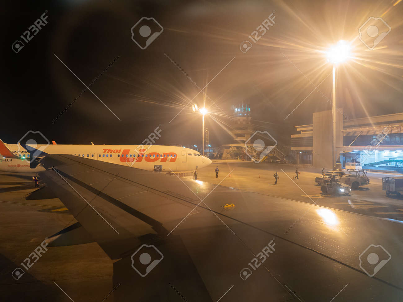 Udon Thani, Thailand - 17 Desember, 2017: Airplane parking on Udon Thani International Airport, Thailand, Thai Lion Airlines and the Fair Light of the High Light Pillar at the airport at night. - 129934539 Udon Thani, Thailand - 17 Desember, 2017: Airplane parking on Udon Thani International Airport, Thailand, Thai Lion Airlines and the Fair Light of the High Light Pillar at the airport at night. - 129934539