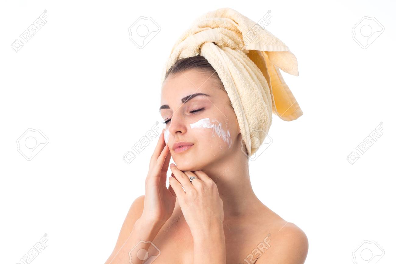 lovely girl takes care her skin with towel on head smeared with