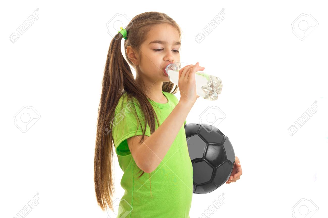 手のドリンクでサッカー ボールと緑のシャツでかわいい女の子水分離に白い背景 の写真素材 画像素材 Image