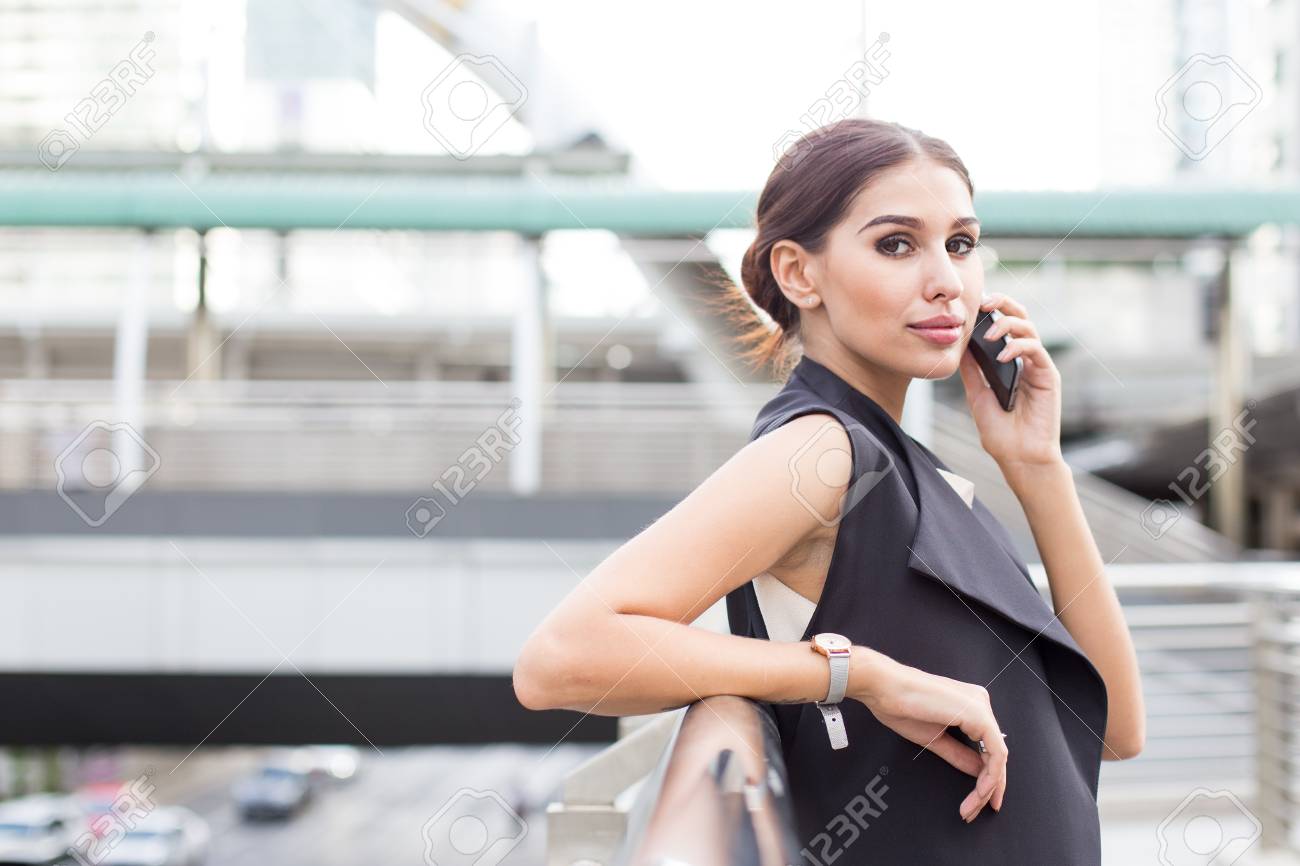 仕事にスマホを使う都会の若き美人ビジネスウーマン リーダーコンセプトの若きビジネスウーマン ビジネスコンセプトを考える白人女性 の写真素材 画像素材 Image