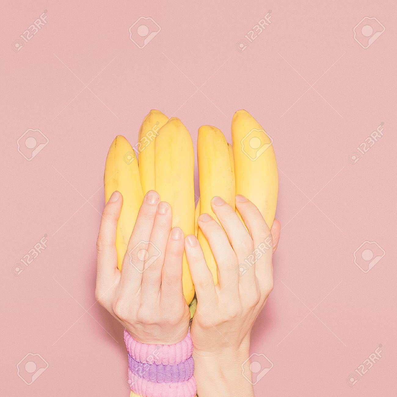 Hands holding bunch of bananas. Fashion, vanilla style minimalism - 37664426 Hands holding bunch of bananas. Fashion, vanilla style minimalism - 37664426