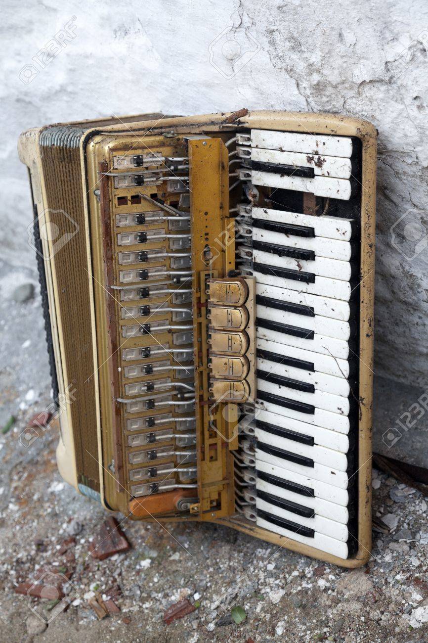 道端に捨てられた破損した古いアコーディオンの写真素材・画像素材