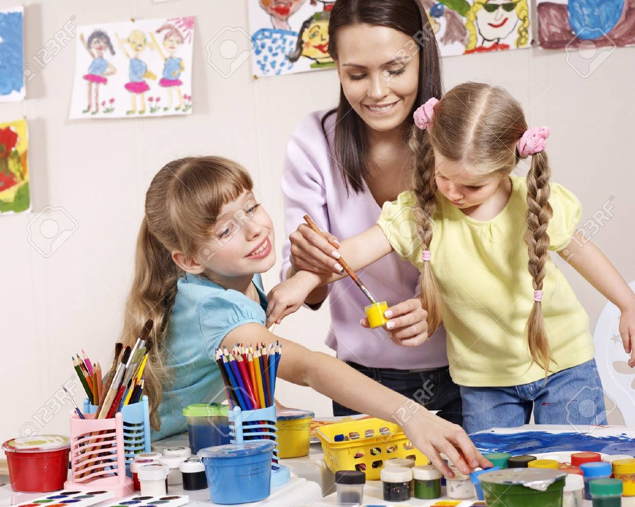Child painting in preschool. Teacher help by little girl. - 9385720 Child painting in preschool. Teacher help by little girl. - 9385720