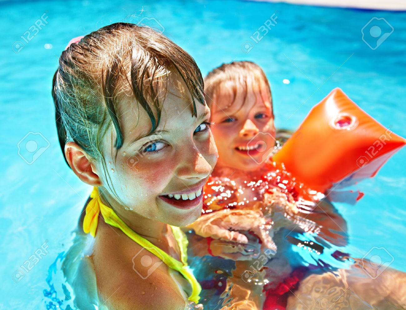 Children with armbands in swimming pool. - 28393739 Children with armbands in swimming pool. - 28393739