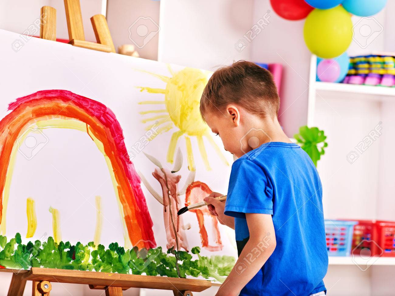 Child painting at easel in school. Education. - 28393911 Child painting at easel in school. Education. - 28393911