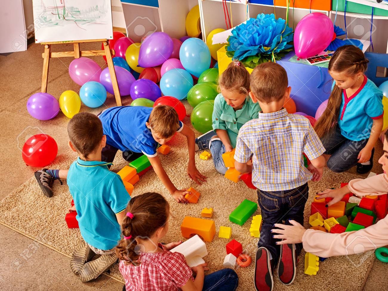 Group children game blocks on floor in kindergarten . Balloons on floor Top view. - 54726546 Group children game blocks on floor in kindergarten . Balloons on floor Top view. - 54726546