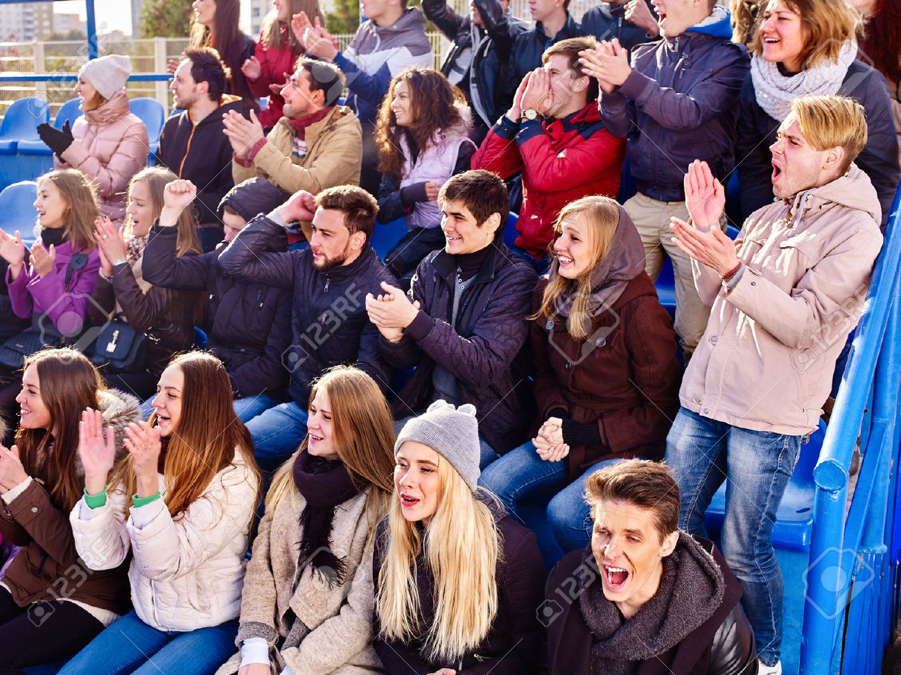 Fans cheering in stadium people applaud your favorite team and singing on tribunes. Group youth group support your favorite team. - 70689881 Fans cheering in stadium people applaud your favorite team and singing on tribunes. Group youth group support your favorite team. - 70689881