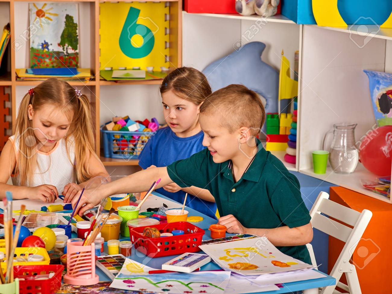 美術学校の授業で絵を描く小さな生徒たち テーブルの上のペンキによる子供の描画 幼稚園の男の子と女の子絵教育は子供たちの創造的な能力を 開発します ベストホームチルドレンクラブ 子供の頃の友情 の写真素材 画像素材 Image