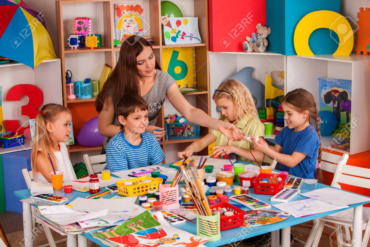 Kids playroom organization of children painting and drawing in kids club. Craft lesson in primary school. Teaching children to do common project. - 95220266 Kids playroom organization of children painting and drawing in kids club. Craft lesson in primary school. Teaching children to do common project. - 95220266