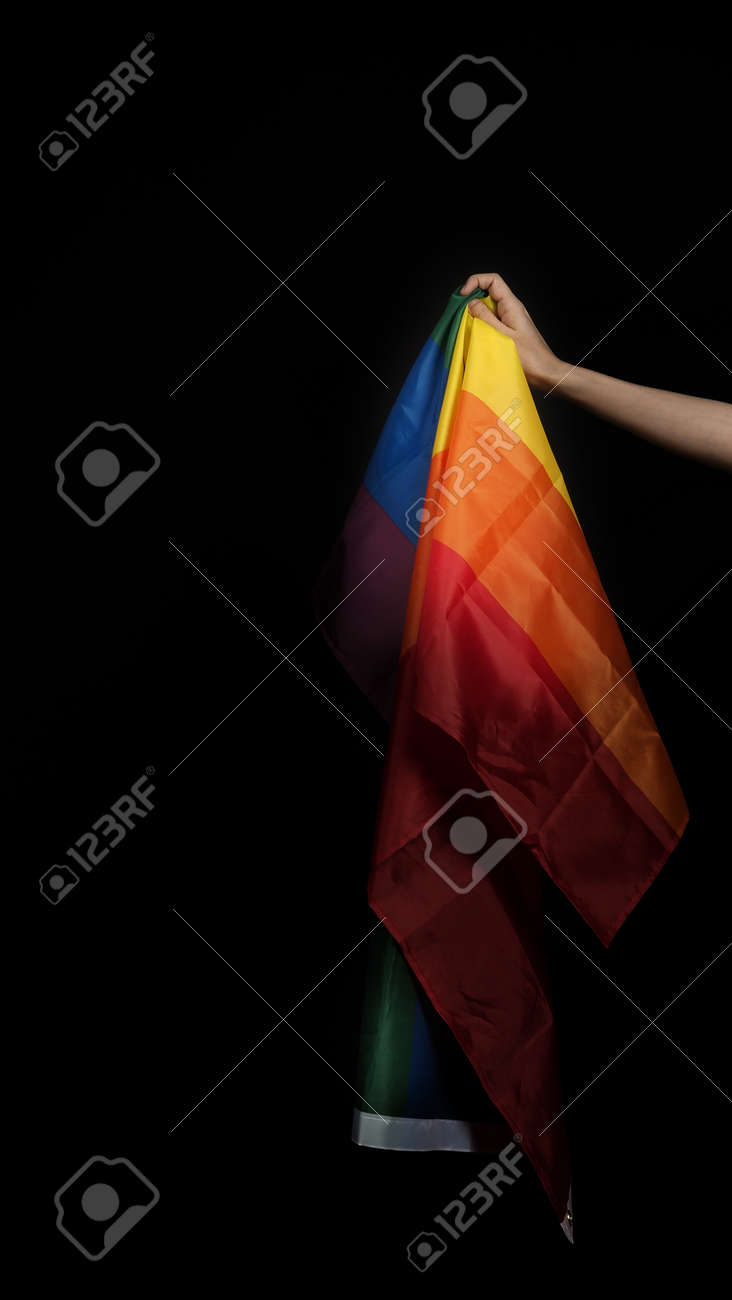 LGBTQ pride flag. Lesbian Gay Bi sexsual Transgender Queer. Homosexsual pride Rainbow flag in hand. black background. Represent symbol of freedom, peace, equality and love. LGBTQ concept. - 169136555 LGBTQ pride flag. Lesbian Gay Bi sexsual Transgender Queer. Homosexsual pride Rainbow flag in hand. black background. Represent symbol of freedom, peace, equality and love. LGBTQ concept. - 169136555