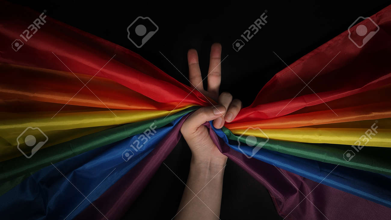 LGBTQ pride flag. Lesbian Gay Bi sexsual Transgender Queer. Homosexsual pride Rainbow flag in hand. black background. Represent symbol of freedom, peace, equality and love. LGBTQ concept. - 169136556 LGBTQ pride flag. Lesbian Gay Bi sexsual Transgender Queer. Homosexsual pride Rainbow flag in hand. black background. Represent symbol of freedom, peace, equality and love. LGBTQ concept. - 169136556