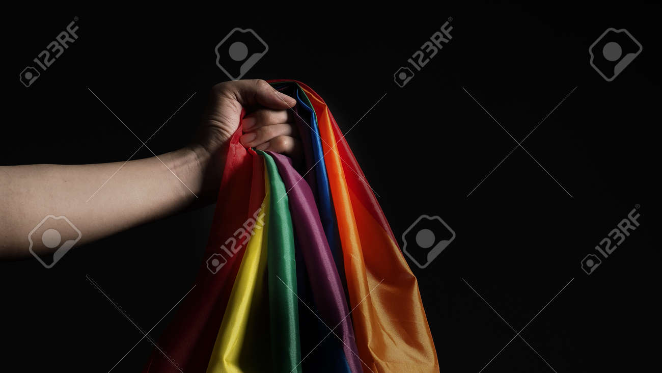 LGBTQ pride flag. Lesbian Gay Bi sexsual Transgender Queer. Homosexsual pride Rainbow flag in hand. black background. Represent symbol of freedom, peace, equality and love. LGBTQ concept. - 169136558 LGBTQ pride flag. Lesbian Gay Bi sexsual Transgender Queer. Homosexsual pride Rainbow flag in hand. black background. Represent symbol of freedom, peace, equality and love. LGBTQ concept. - 169136558