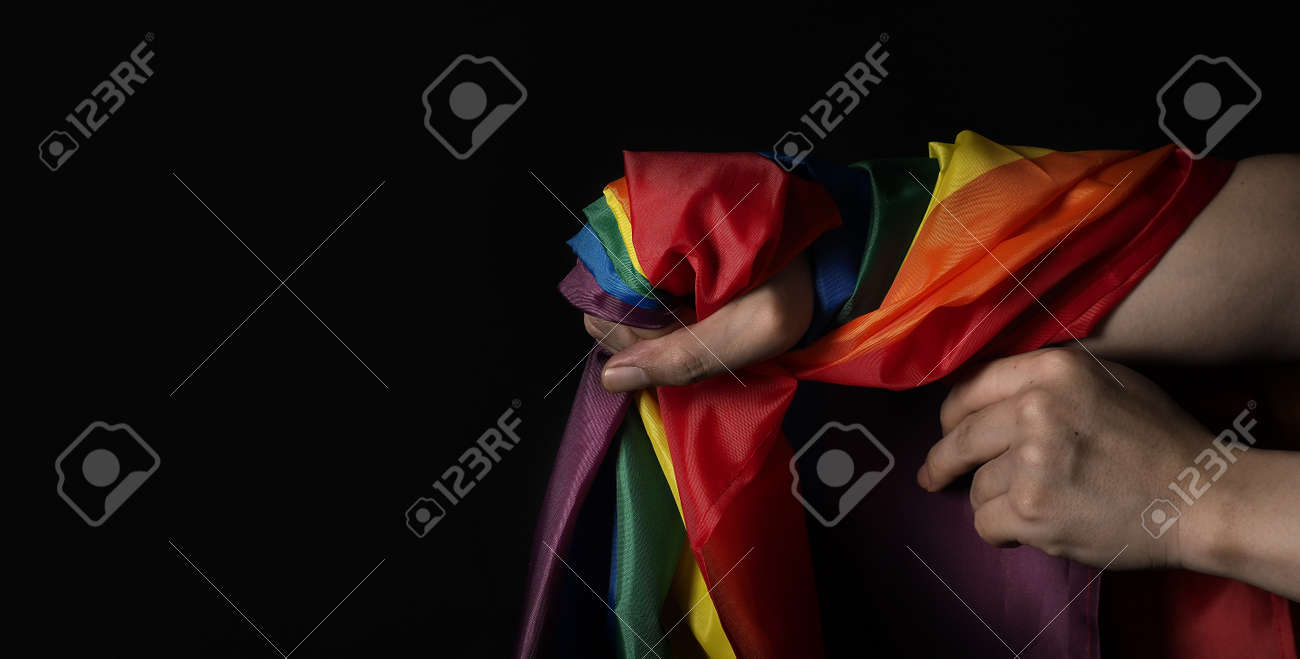 LGBTQ pride flag. Lesbian Gay Bi sexsual Transgender Queer. Homosexsual pride Rainbow flag in hand. black background. Represent symbol of freedom, peace, equality and love. LGBTQ concept. - 169136576 LGBTQ pride flag. Lesbian Gay Bi sexsual Transgender Queer. Homosexsual pride Rainbow flag in hand. black background. Represent symbol of freedom, peace, equality and love. LGBTQ concept. - 169136576