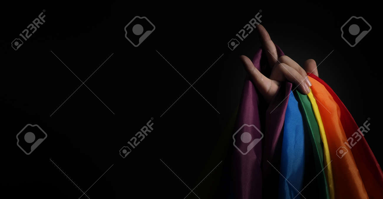 LGBTQ pride flag. Lesbian Gay Bi sexsual Transgender Queer. Homosexsual pride Rainbow flag in hand. black background. Represent symbol of freedom, peace, equality and love. LGBTQ concept. - 169136626 LGBTQ pride flag. Lesbian Gay Bi sexsual Transgender Queer. Homosexsual pride Rainbow flag in hand. black background. Represent symbol of freedom, peace, equality and love. LGBTQ concept. - 169136626