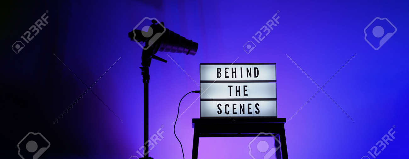 Behind the scenes letterboard text on Lightbox or Cinema Light box. Movie clapperboard megaphone and director chair beside. Background LED color change loop. static camera in video production studio. - 170416176 Behind the scenes letterboard text on Lightbox or Cinema Light box. Movie clapperboard megaphone and director chair beside. Background LED color change loop. static camera in video production studio. - 170416176