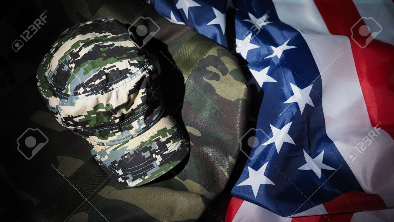 American flag and Military hat or bag. Top view angle. Soldier hat or helmet with national american flag on black background. Represent military concept by camouflage object and USA nation flag. - 170314451 American flag and Military hat or bag. Top view angle. Soldier hat or helmet with national american flag on black background. Represent military concept by camouflage object and USA nation flag. - 170314451
