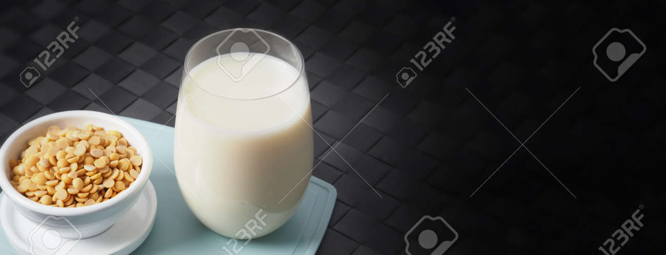 Soy milk with no sugar added in a glass on a green color plastic plate mat. Close-up images of home made healthy soy milk drink and soy beans in small bowl. Black background in a studio shot. Soymilk. - 171186459 Soy milk with no sugar added in a glass on a green color plastic plate mat. Close-up images of home made healthy soy milk drink and soy beans in small bowl. Black background in a studio shot. Soymilk. - 171186459