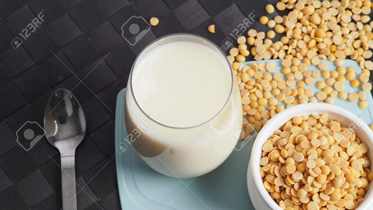 Soy milk with no sugar added in a glass on a green color plastic plate mat. Close-up images of home made healthy soy milk drink and soy beans in small bowl. Black background in a studio shot. Soymilk. - 171186562 Soy milk with no sugar added in a glass on a green color plastic plate mat. Close-up images of home made healthy soy milk drink and soy beans in small bowl. Black background in a studio shot. Soymilk. - 171186562