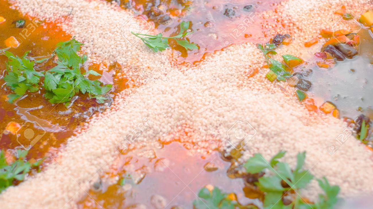 Rice being added to the vegetarian meal together with veggie stock - 56219602 Rice being added to the vegetarian meal together with veggie stock - 56219602
