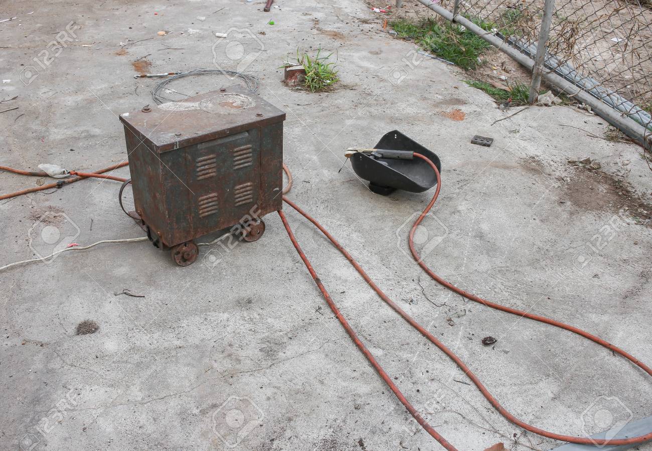 古い錆溶接機器 溶接マスク ケーブルおよび電気アーク溶接 セメントの床用電極付きのロッド ホルダーの古い静物 フォーカス溶接錆を選択します の写真素材 画像素材 Image