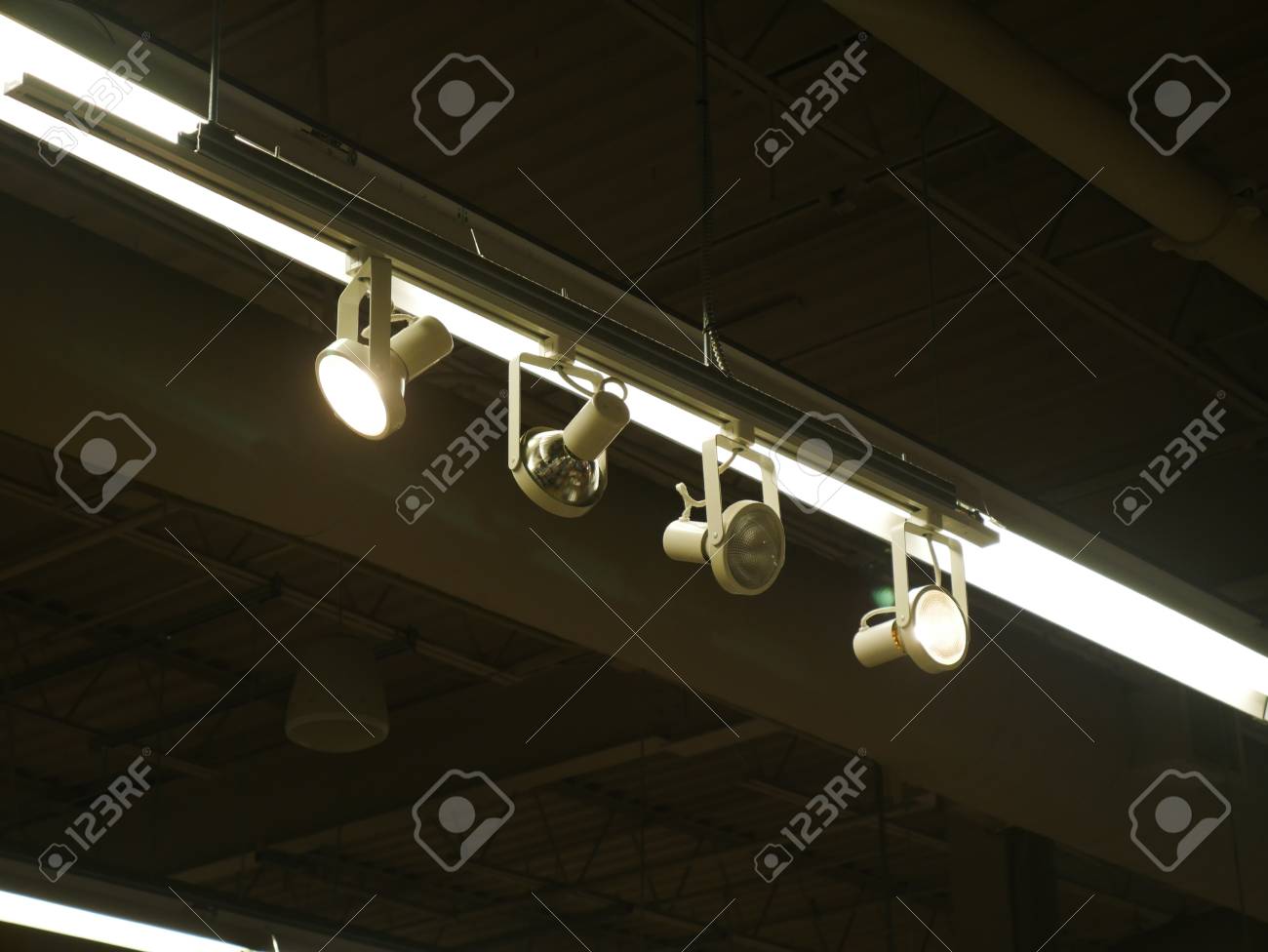 Set Of Spot Lights On A Rail Hanging From The Ceiling Stock Photo