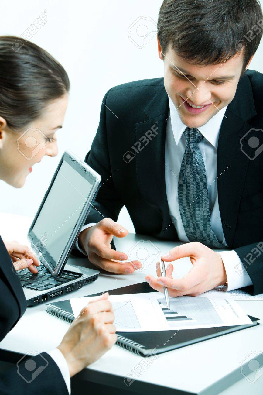 stock photo vertical image of two business partners looking at document at meeting and discussing it