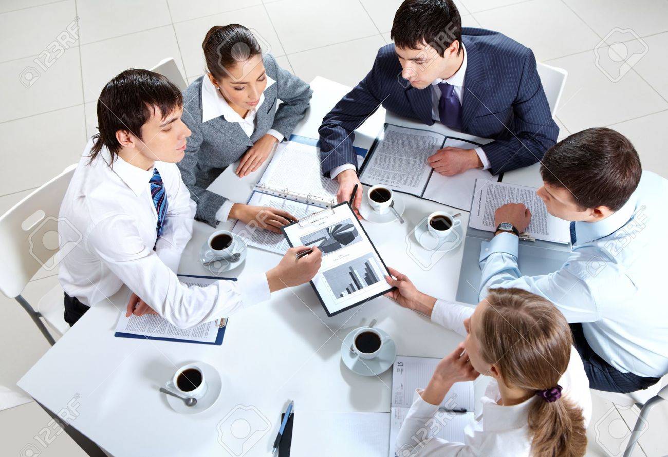 Above View Of Business Team Sitting Around Table And Working With Papers  Stock Photo, Picture And Royalty Free Image. Image 9633477.