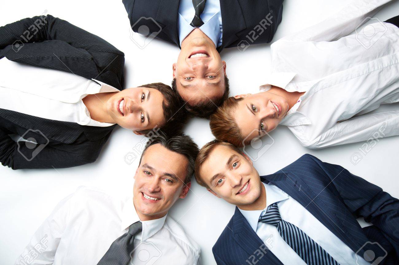 Five Business People Lying On The Floor Looking At Camera And