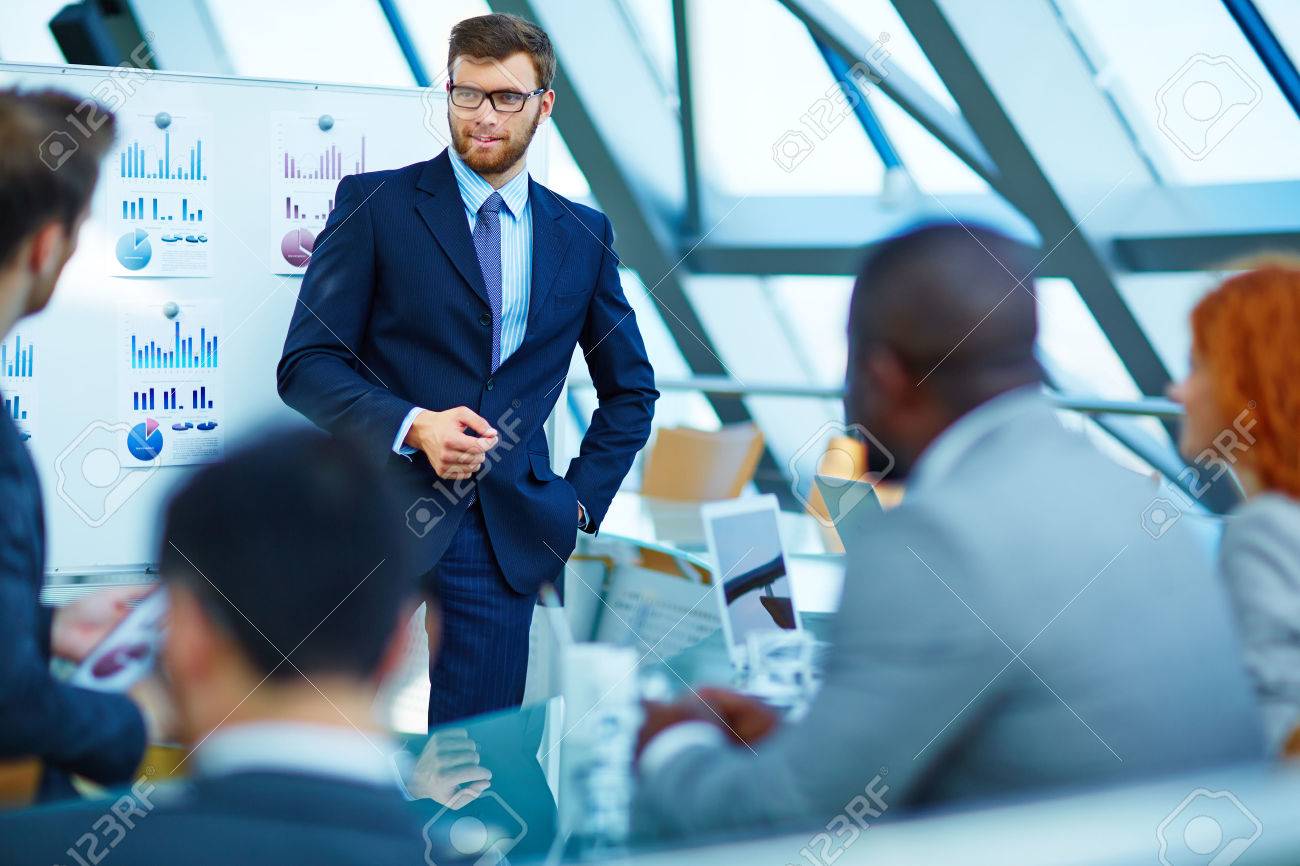 Young businessman making presentation to his colleagues - 50673376 Young businessman making presentation to his colleagues - 50673376
