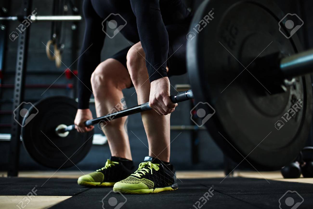 Active young man training with barbell in gym - 54721092 Active young man training with barbell in gym - 54721092