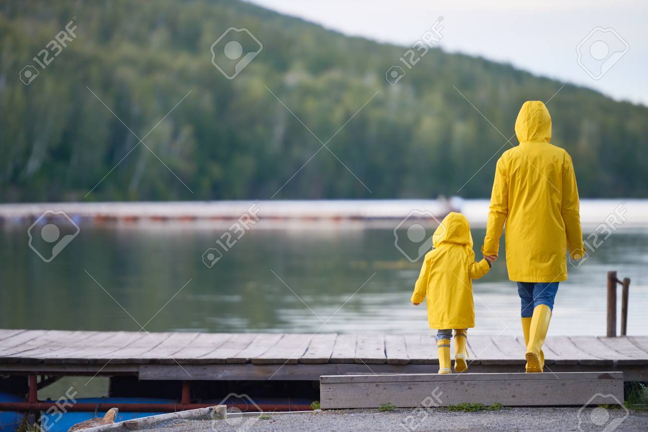 Vue Arriere De La Femme Et De L Enfant En Cire Jaune Et Bottes En Caoutchouc A Marcher Vers La Riviere Banque D Images Et Photos Libres De Droits Image