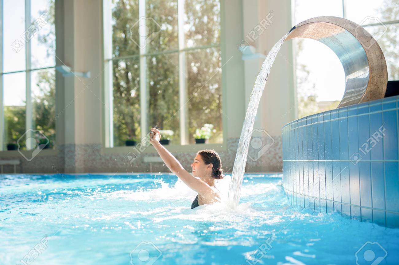 Woman under manmade waterfall - 87945950 Woman under manmade waterfall - 87945950
