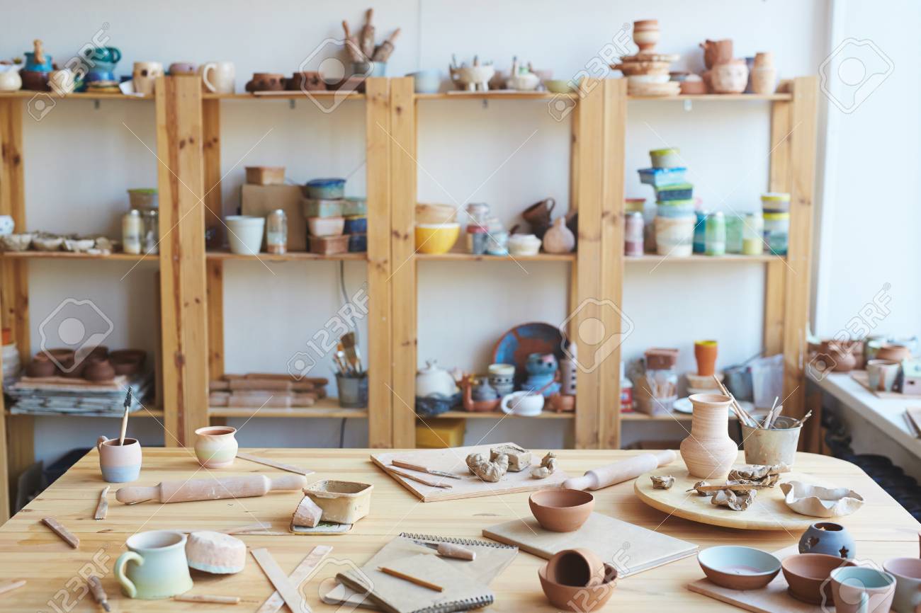 Messy workshop with handmade clay vases, pots and jars made by professional potter - 100143230 Messy workshop with handmade clay vases, pots and jars made by professional potter - 100143230