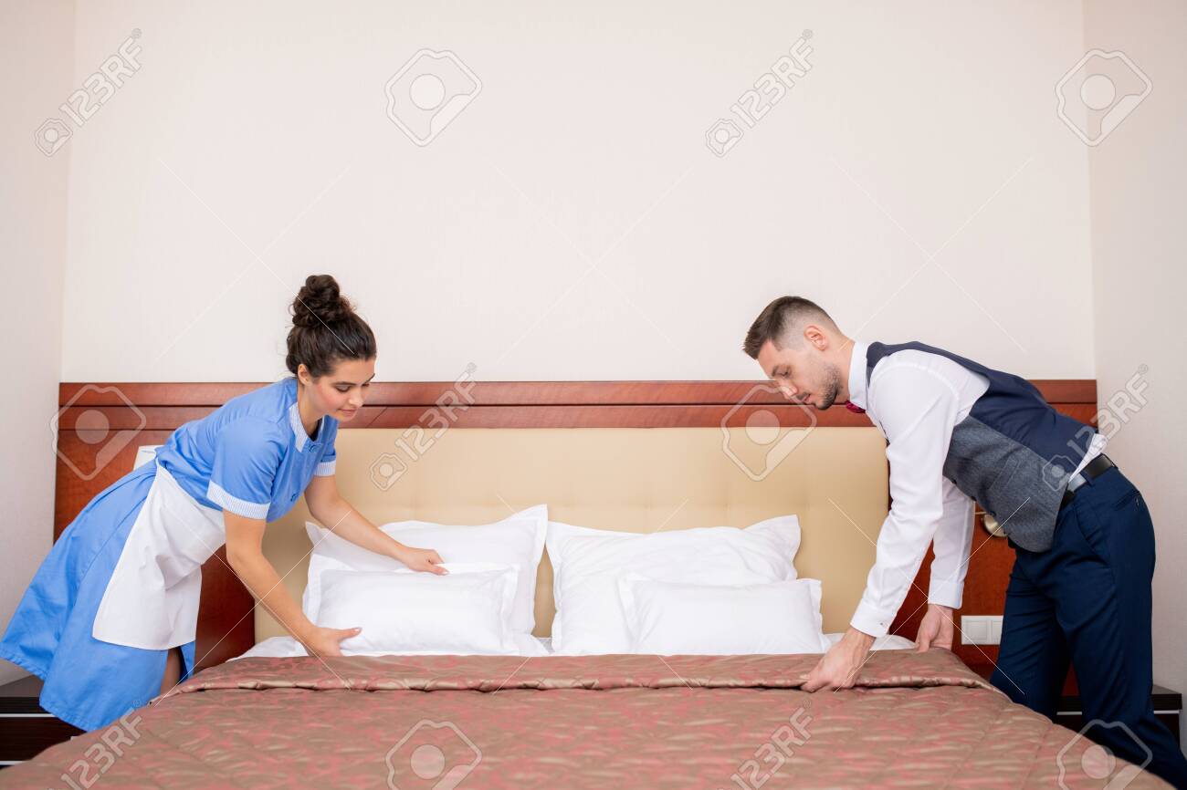 Young Porter And Chamber Maid Bending Over Bed While Making It In The  Morning Stock Photo, Picture and Royalty Free Image. Image 132312906.