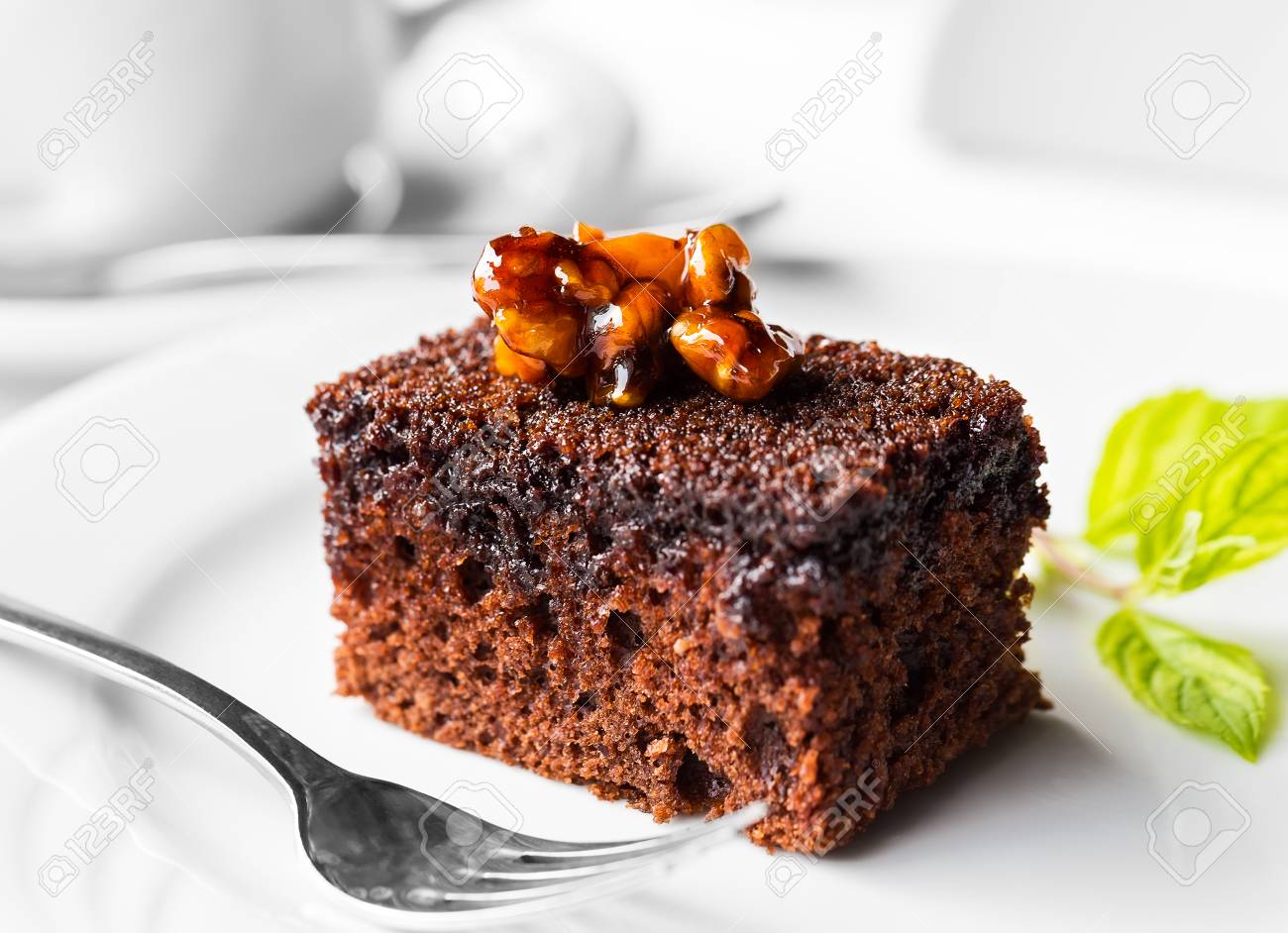 Chocolate cake with mint leaf on plate on table - 47187534 Chocolate cake with mint leaf on plate on table - 47187534