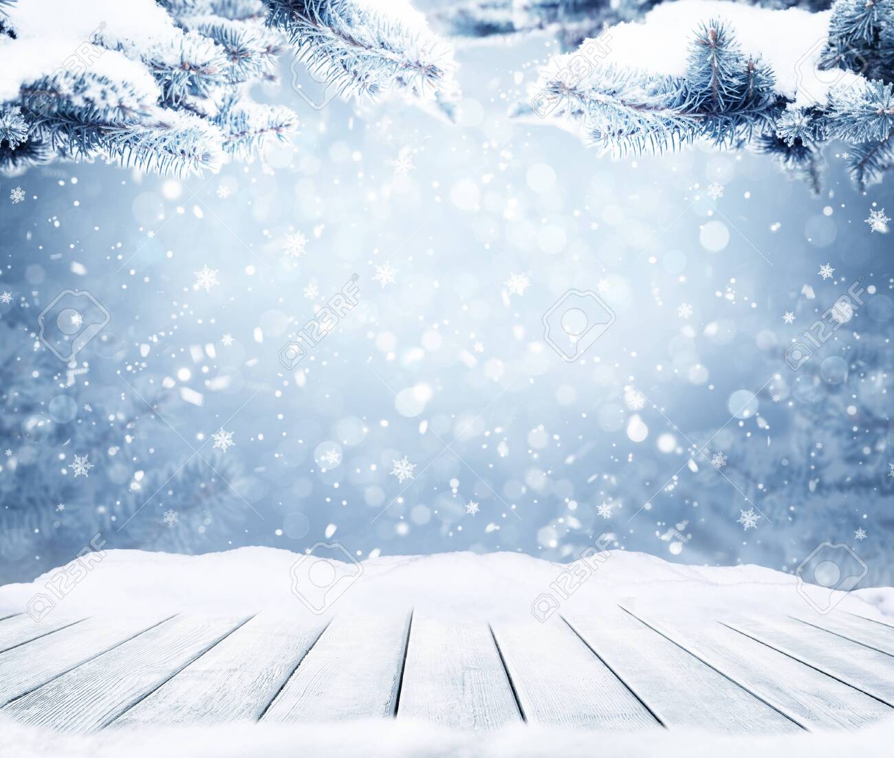 Winter decorative Christmas background with bokeh lights, snowflakes and empty old wooden table. Christmas and Happy New Year blue background with snowflake. Winter landscape with falling snow and fir tree branches. - 134416868 Winter decorative Christmas background with bokeh lights, snowflakes and empty old wooden table. Christmas and Happy New Year blue background with snowflake. Winter landscape with falling snow and fir tree branches. - 134416868
