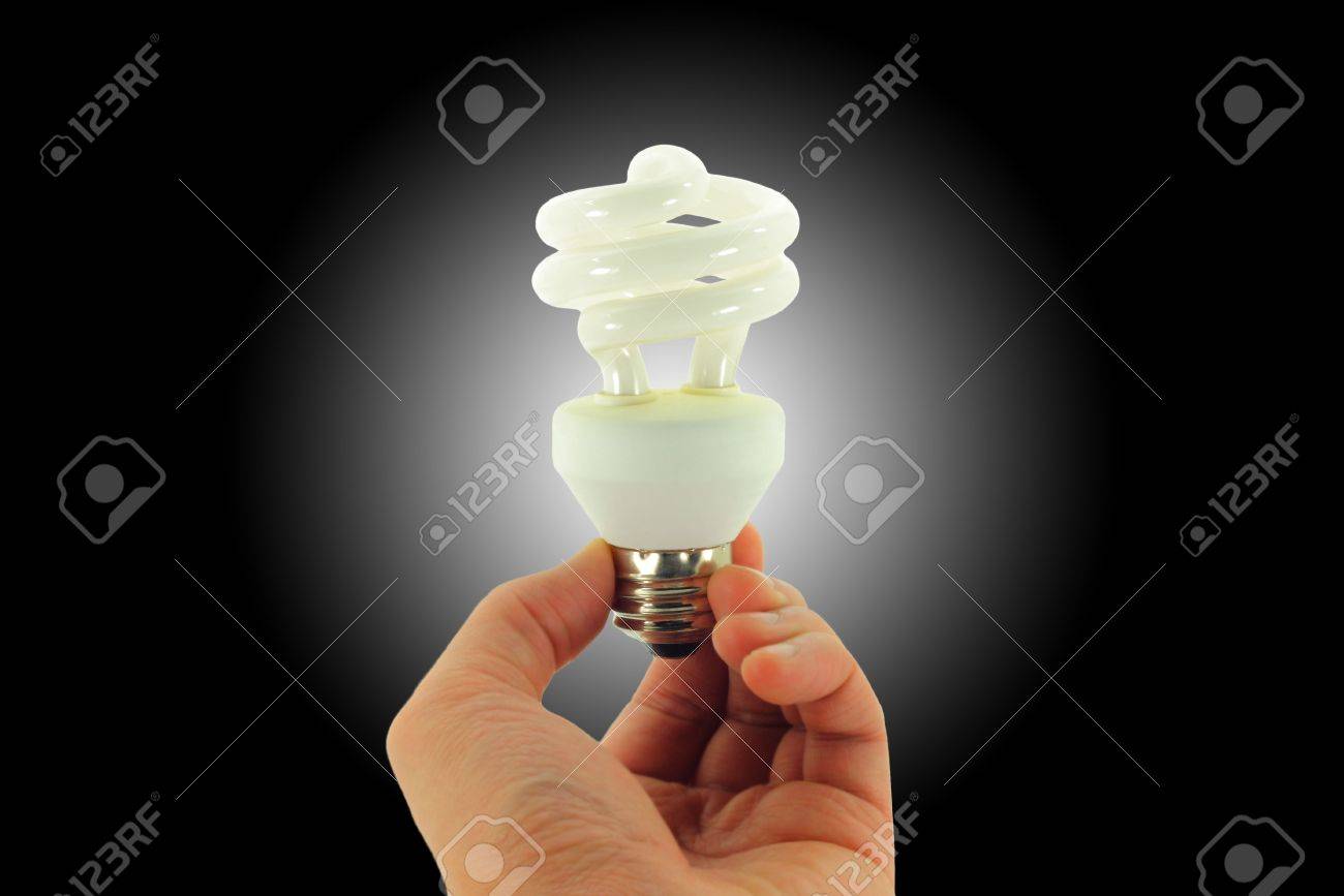 Compact Fluorescent Light bulb held in hand isolated on a black background with a white spotlight - 4019546 Compact Fluorescent Light bulb held in hand isolated on a black background with a white spotlight - 4019546