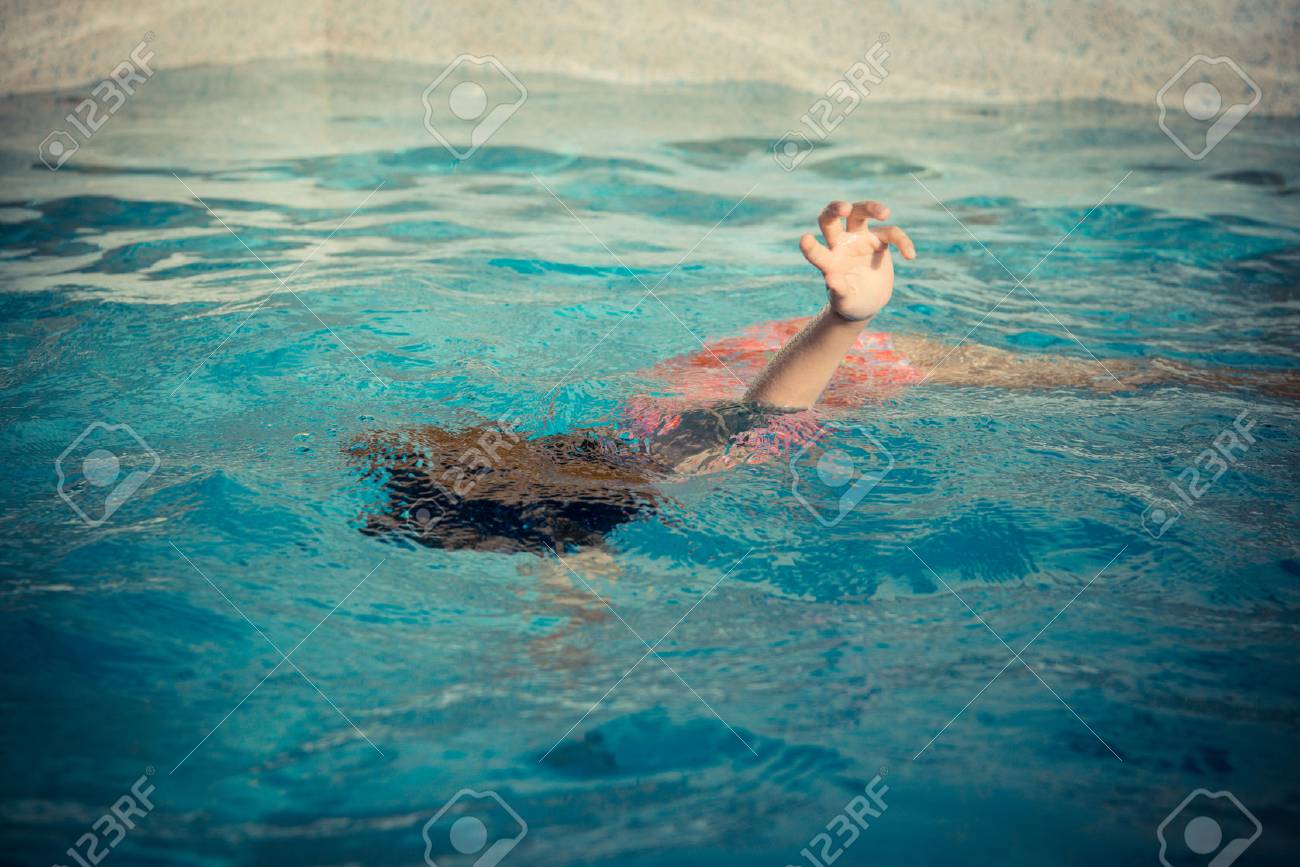 若い女の子プールに浮いていると手のための呼び出しを表示する際に彼女の夏の休暇で遊んでと水で溺れます の写真素材 画像素材 Image