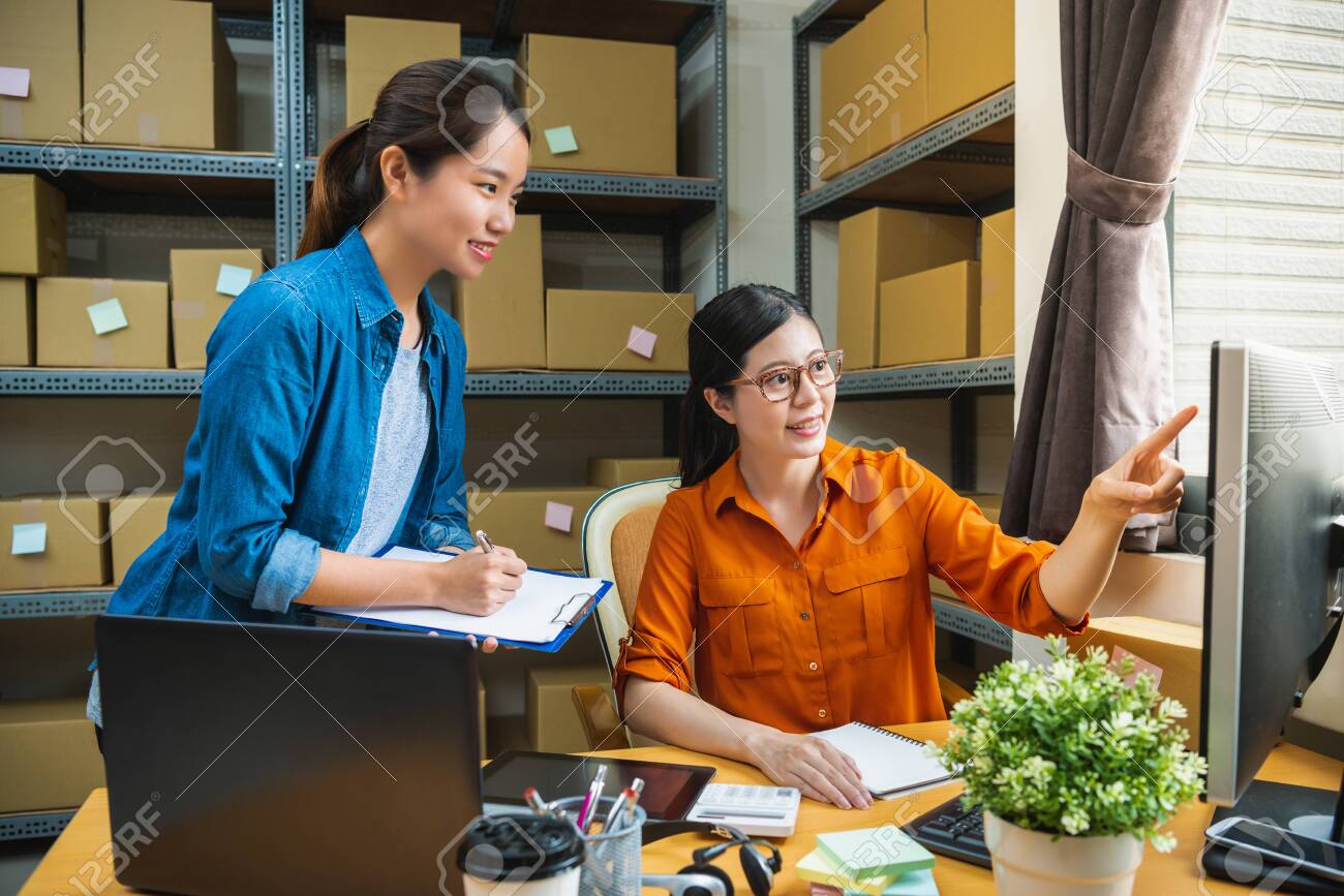 manager in the delivery company is teaching the new employee to check the list, and the new staff is making note - 109213971 manager in the delivery company is teaching the new employee to check the list, and the new staff is making note - 109213971