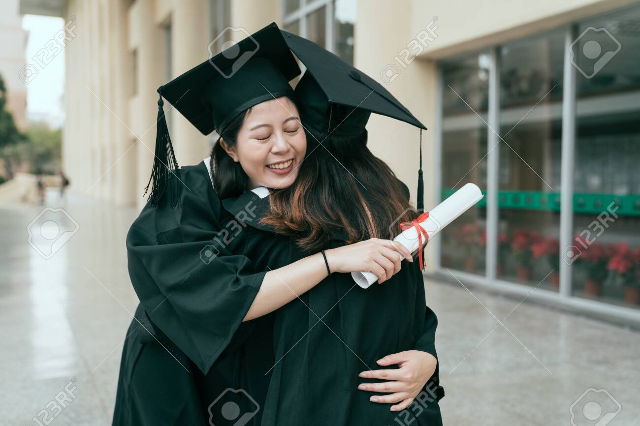 Happy asian female graduate with classmate celebrating graduation. young girls best friends hugging each other close eyes love care bye cannot bear to separate. friendship authentic lifestyle concept - 123192812 Happy asian female graduate with classmate celebrating graduation. young girls best friends hugging each other close eyes love care bye cannot bear to separate. friendship authentic lifestyle concept - 123192812