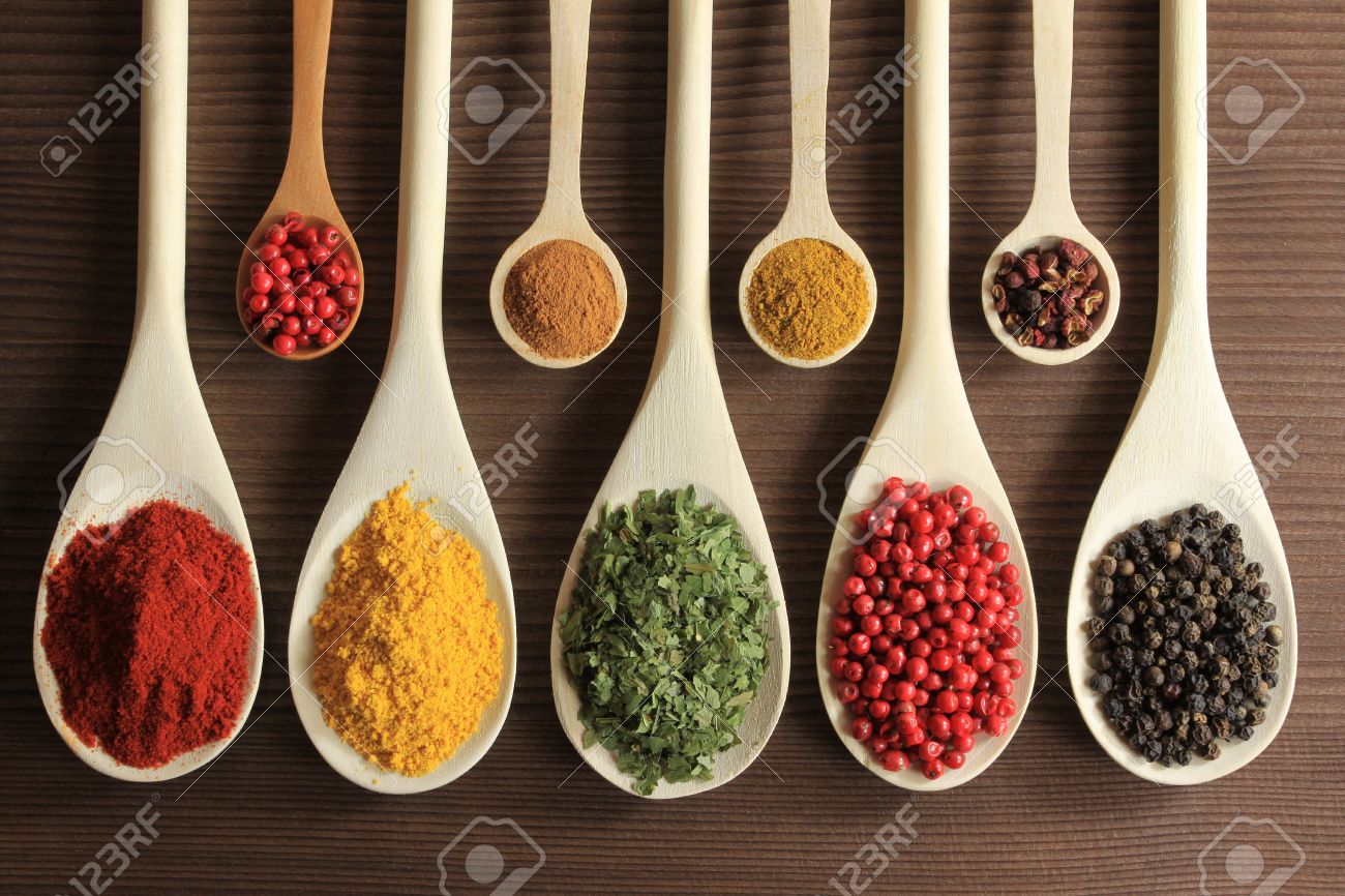 Colorful spices in wooden spoons - beautiful kitchen image. - 9418849 Colorful spices in wooden spoons - beautiful kitchen image. - 9418849
