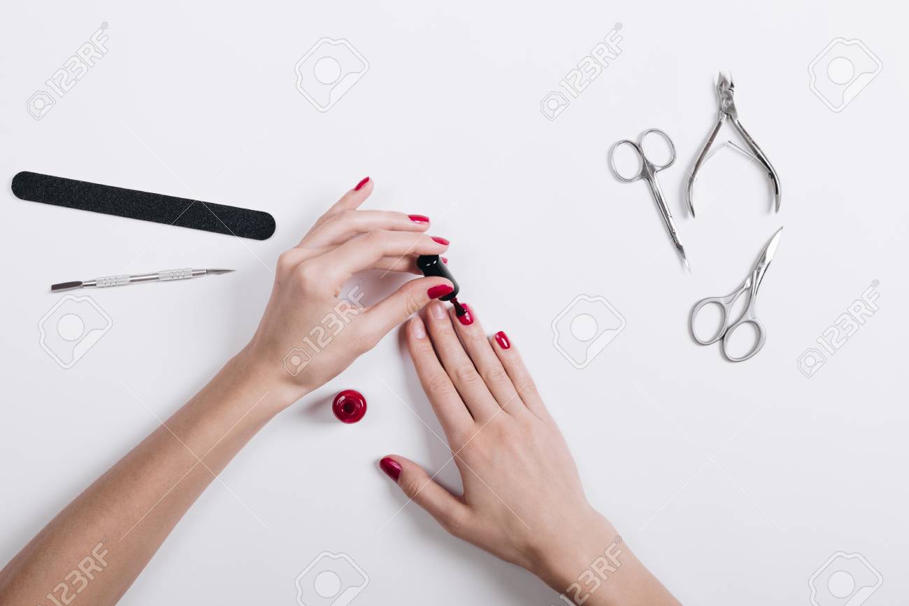 女性の手に赤漆塗りの爪 マニキュア用の白いテーブル アクセサリーにうそをつく の写真素材 画像素材 Image