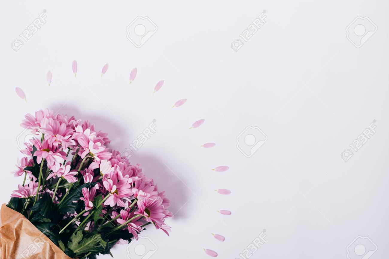 top view of a bouquet of pink flowers in wrapping paper on a white pink flower wrapping paper