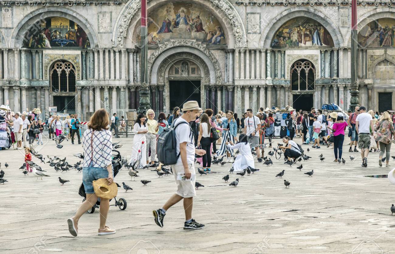 VENICE, ITALY - 25 August, 2018: St Marks Square in Venice with many tourists and pigeons on a spring warm day - 137706418 VENICE, ITALY - 25 August, 2018: St Marks Square in Venice with many tourists and pigeons on a spring warm day - 137706418