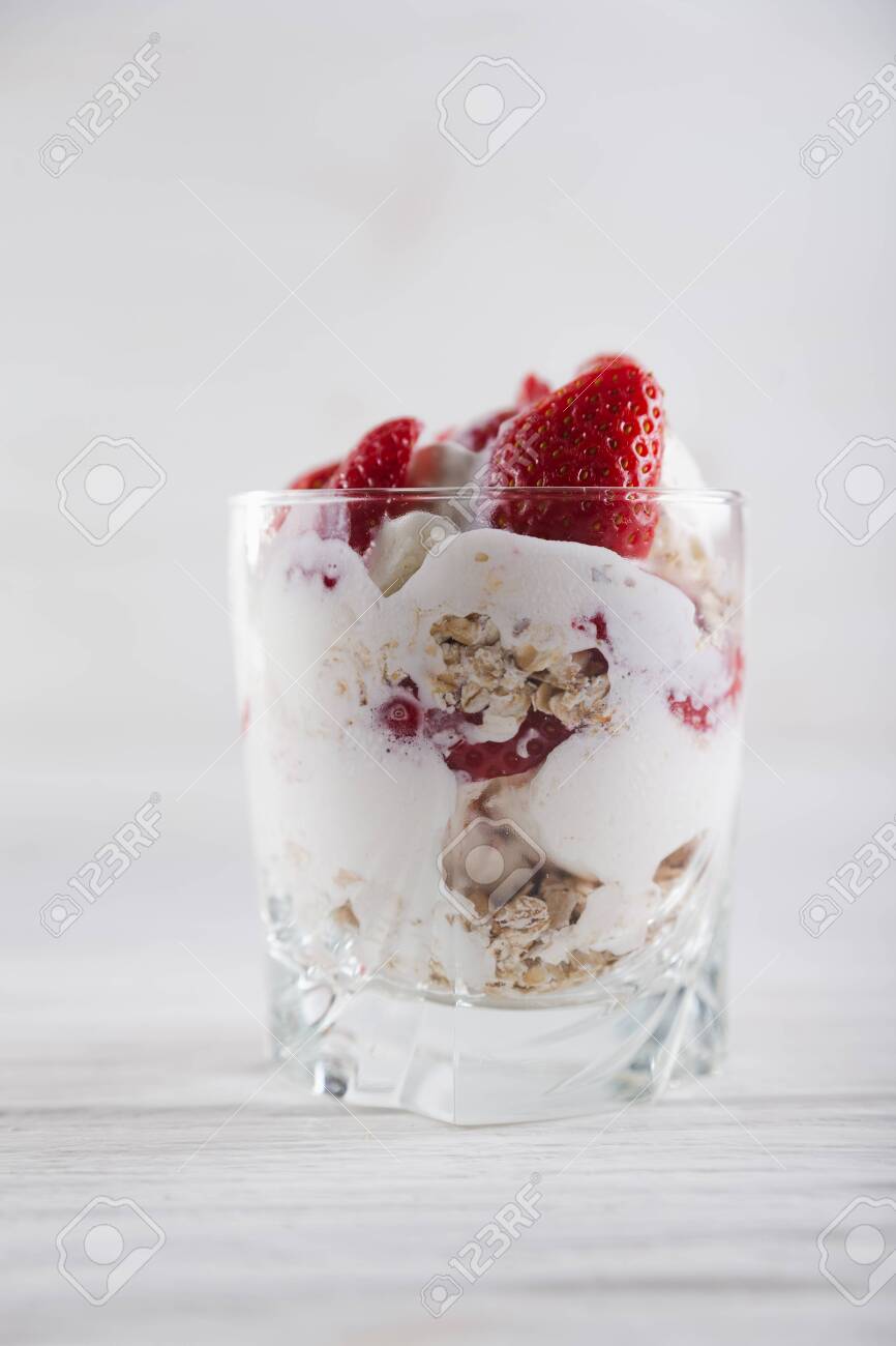 Strawberry dessert in a plate with ice cream and cream on a white wooden background. - 151260955 Strawberry dessert in a plate with ice cream and cream on a white wooden background. - 151260955
