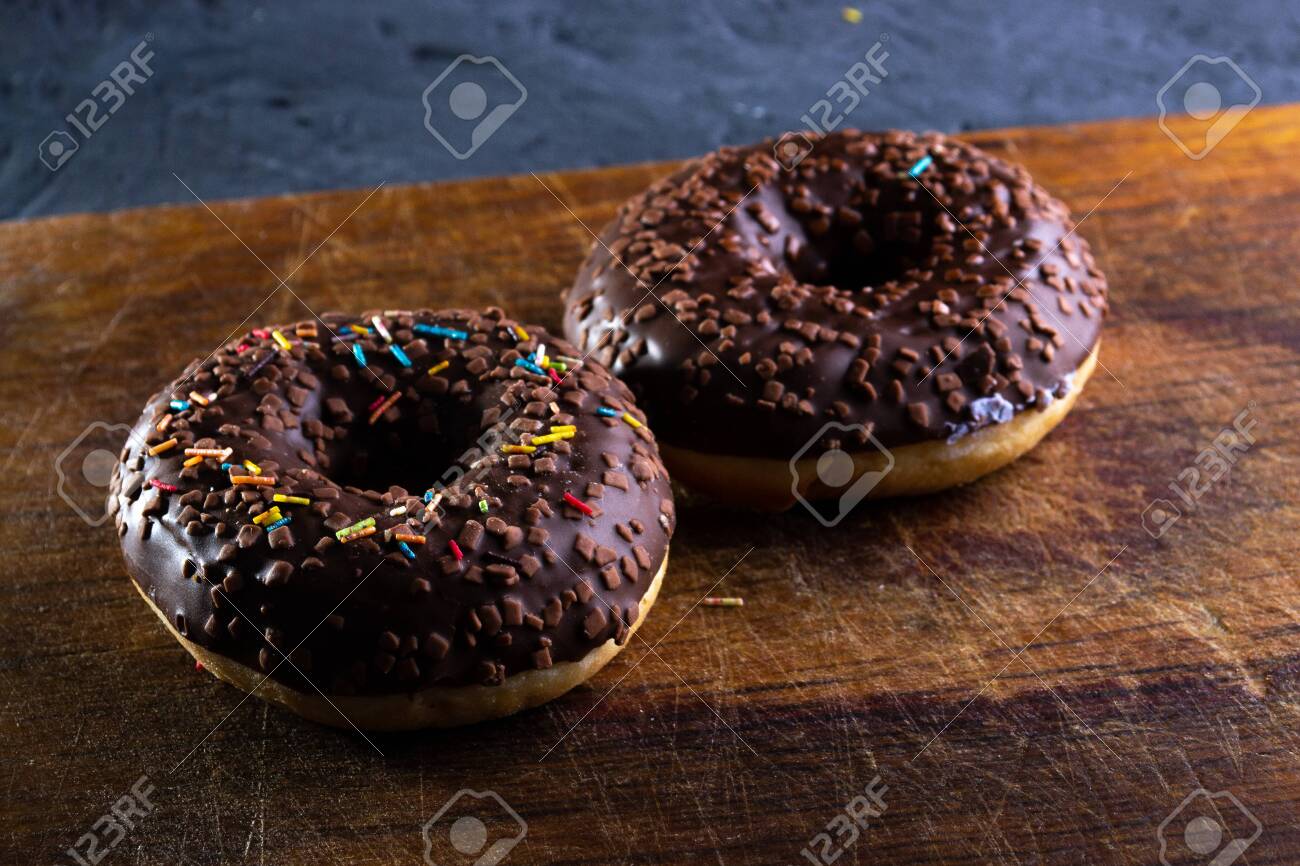 Donuts on a wooden board on a blue concrete background. - 151261064 Donuts on a wooden board on a blue concrete background. - 151261064