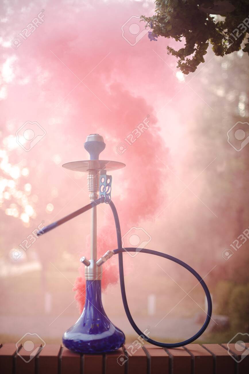 Hookah outdoors on a background of colored smoke. - 151332823 Hookah outdoors on a background of colored smoke. - 151332823