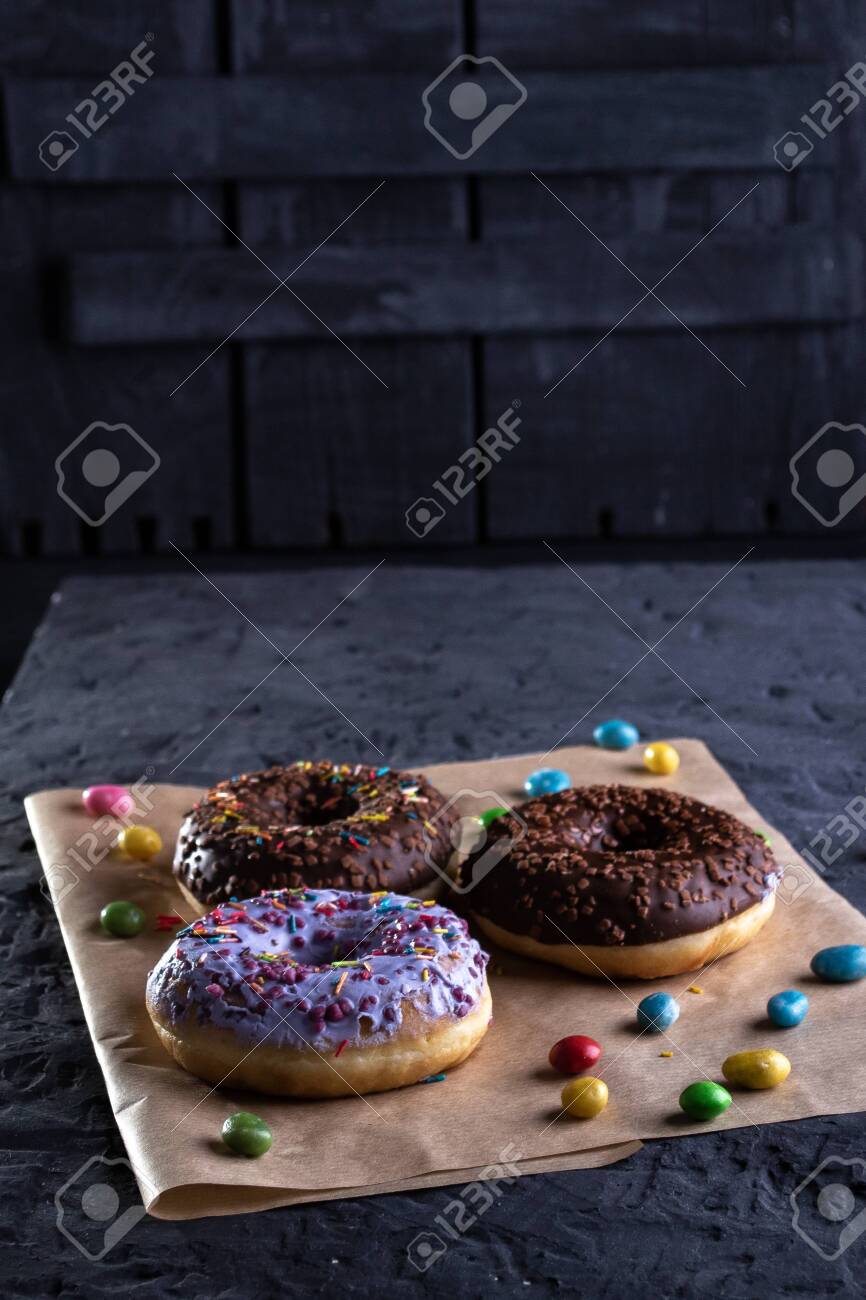 Donuts on a wooden board on a blue concrete background. - 151260936 Donuts on a wooden board on a blue concrete background. - 151260936